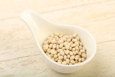 Kase ahşap arka plan üzerinde beyaz kuru fasulye