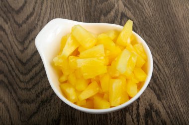 Konserve ananas parçaları ahşap masa arka plan üzerinde