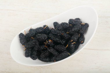 Kase ahşap arka plan üzerinde siyah dut yığın