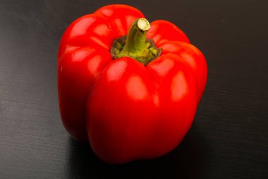 Siyah ahşap arka plan üzerinde kırmızı dolmalık biber