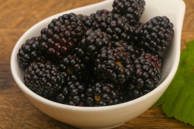 Böğürtlen ahşap masa arka plan üzerinde kase