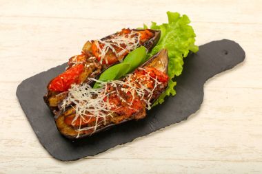 Et ve ahşap arka plan üzerinde peynir ile doldurulmuş patlıcan