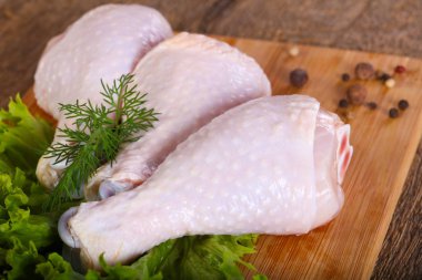 Ahşap arka plan üzerinde yemek pişirmek için çiğ tavuk budu