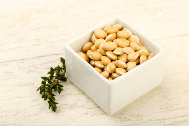 Ahşap arka plan üzerinde kapta çiğ beyaz fasulye