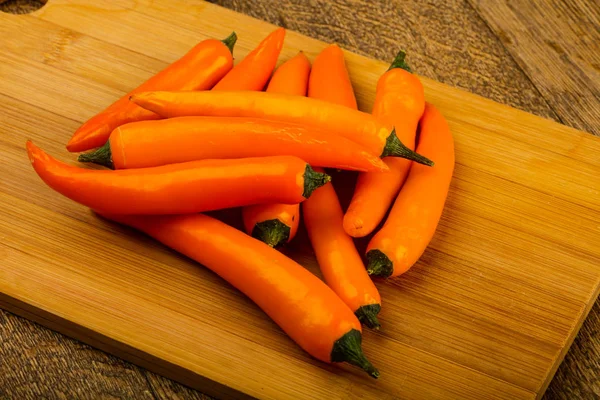 Sıcak sarı biber yığın ahşap arka plan üzerinde 