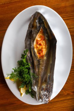 Sebzeli Fırında Alabalık limon ve maydanoz ahşap arka plan üzerinde servis