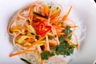 Şehriye, pastırma ve beyaz tabakta sebze salatası