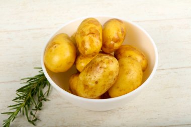 Ahşap masa arka plan üzerinde otlar ile ham genç patates