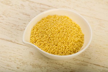 Ham kuskus yığın kase ahşap arka plan üzerinde