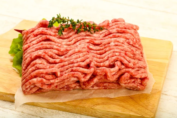 Kekik ve acı biber, ahşap masa arka plan ile çiğ kıyma et