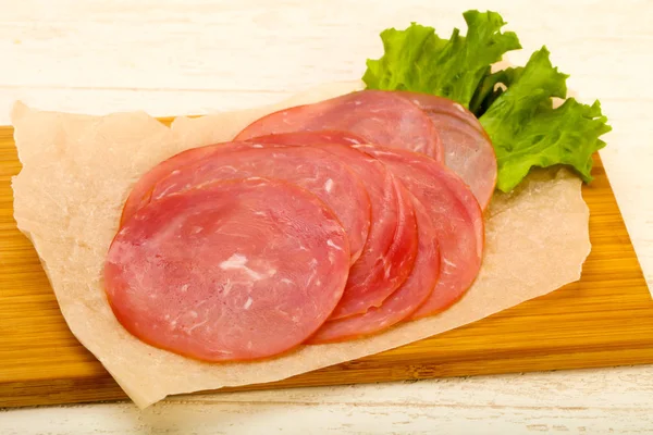 Wurst Scheiben Geschnitten Mit Salatblättern Über Holzuntergrund — Stockfoto