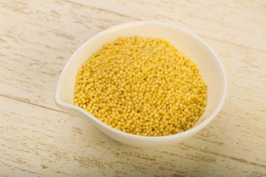 Ham kuskus yığın kase ahşap arka plan üzerinde