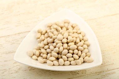 Kase ahşap arka plan üzerinde beyaz kuru fasulye