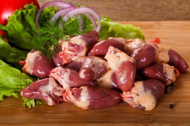 Çiğ tavuk kalpler yığın ahşap arka plan üzerine kekik Şubesi ile