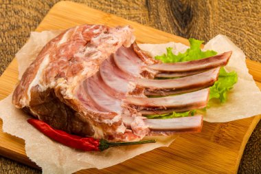 Ham kuzu kaburga ile biber ahşap arka plan üzerinde yemek pişirmek için hazır