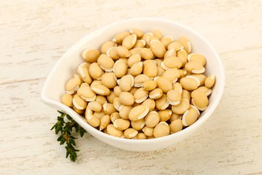 Ahşap arka plan üzerinde kapta çiğ beyaz fasulye