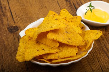 Ahşap arka plan üzerinde peynir soslu cips