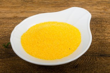 Kase çiğ polenta ahşap arka plan üzerinde yemek pişirmek için hazır