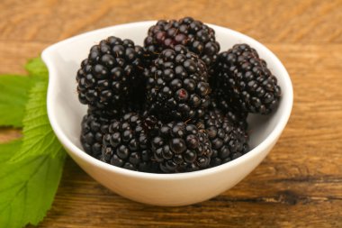 Böğürtlen ahşap masa arka plan üzerinde kase