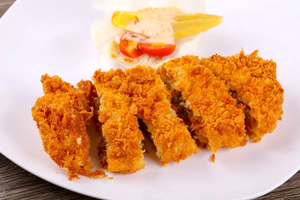 Peynir ve salata ile gevrek domuz eti beyaz tabak içinde bırakır