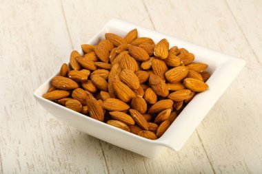 Badem ahşap arka plan üzerinde kase