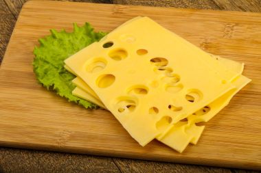 Ahşap arka plan üzerinde dilimlenmiş peynir salata yaprakları