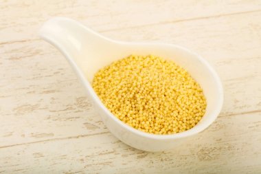 Ham kuskus yığın kase ahşap arka plan üzerinde