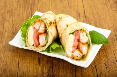 Ahşap arka plan üzerinde tavuk ekmek rulo ile salata yaprakları