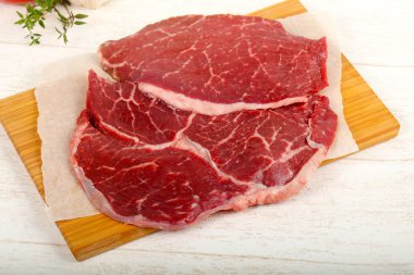 Ham sığır eti biftek ahşap arka plan üzerinde yemek pişirmek için hazır