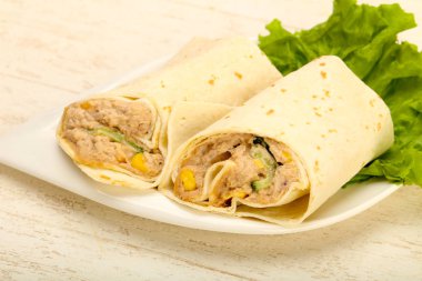 Ton balıklı ekmek rulo ile salata yaprakları ahşap masa arka plan üzerinde