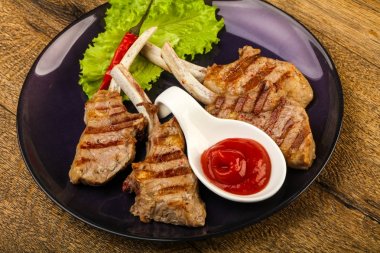 Salata yaprakları ahşap arka plan üzerinde hizmet domates soslu kuzu ızgara