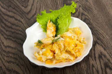 Ahşap arka plan üzerinde beyaz tabak içinde pişmiş yumurta