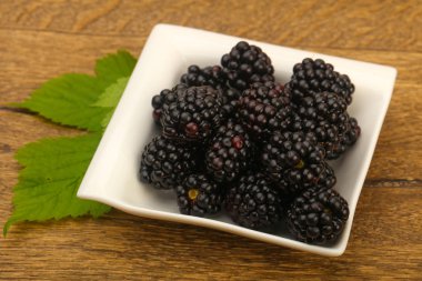 Böğürtlen ahşap masa arka plan üzerinde kase