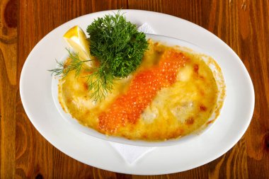 Ahşap masa arka plan üzerinde kırmızı havyar ile Somon cocotte