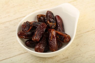 Tatlı meyve yığın kase ahşap arka plan üzerinde tarihleri.