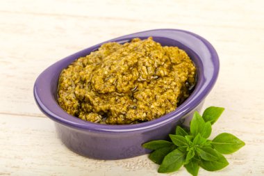 Fesleğenli pesto sos kapta ahşap arka plan üzerinde bırakır.