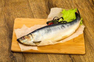 Biber ve baharat ahşap arka plan üzerinde salamura ringa balığı