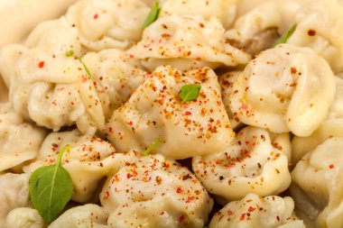 Otlar, yağlar ve baharatlar ile haşlanmış mantı 