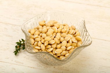 Ahşap arka plan üzerinde kapta çiğ beyaz fasulye