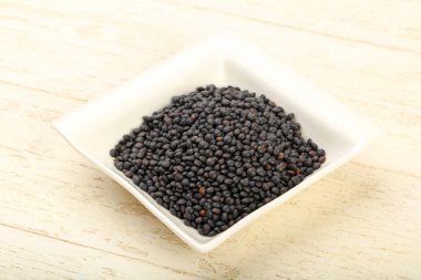 Kase üzerinde ahşap arka plan yemek pişirmek için hazır siyah mercimek