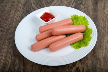 Salata ve ahşap arka plan üzerine ketçap ile sosis haşlama