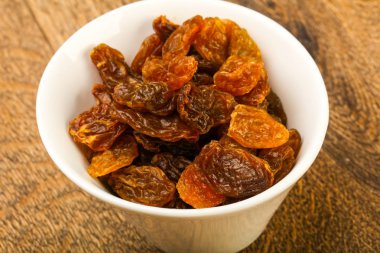 Ahşap arka plan üzerinde kase kuru kuru üzüm