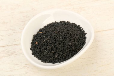 Ahşap arka plan üzerinde siyah çörek otu tohumu yığın 