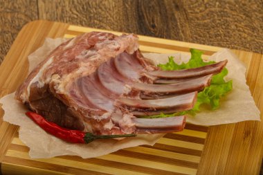 Ham kuzu kaburga ile biber ahşap arka plan üzerinde yemek pişirmek için hazır