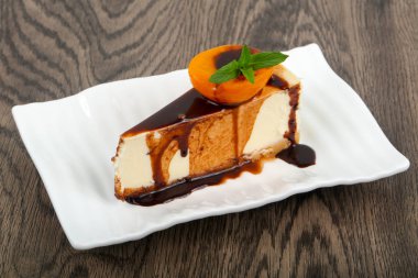 Peynirli kek çikolata ve beyaz tabak içinde kayısı ile