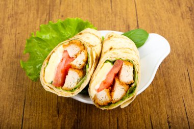 Ahşap arka plan üzerinde tavuk ekmek rulo ile salata yaprakları