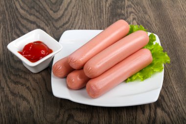 Salata ve ahşap arka plan üzerine ketçap ile sosis haşlama