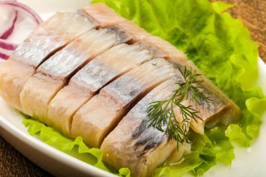 Ahşap arka plan üzerinde ringa balığı filetosu dereotu ve soğan dilimlenmiş