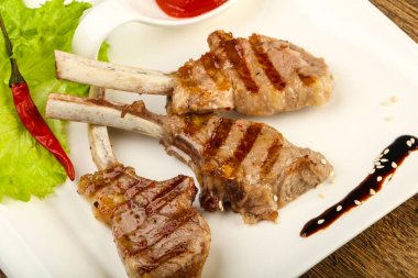 Salata yaprakları ahşap arka plan üzerinde hizmet domates soslu kuzu ızgara