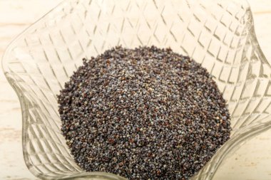 Ahşap arka plan üzerinde kase haşhaş tohumu